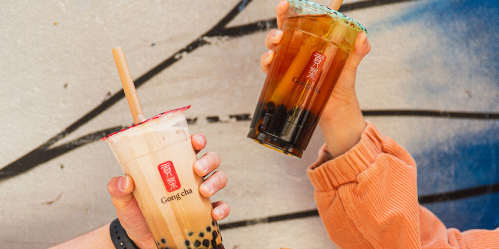 three hands holding various Gong cha bubble tea drinks